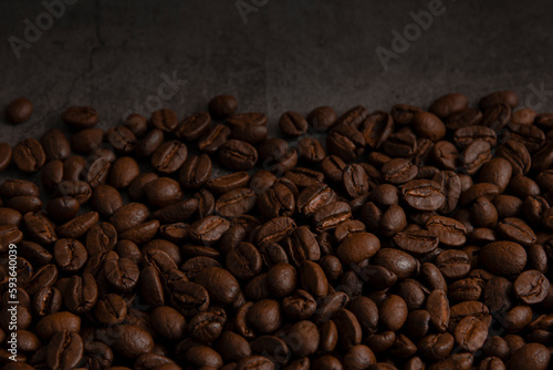 Roasted coffee beans on dark dark background.