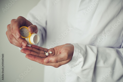 Pills in doctor's hand, white background