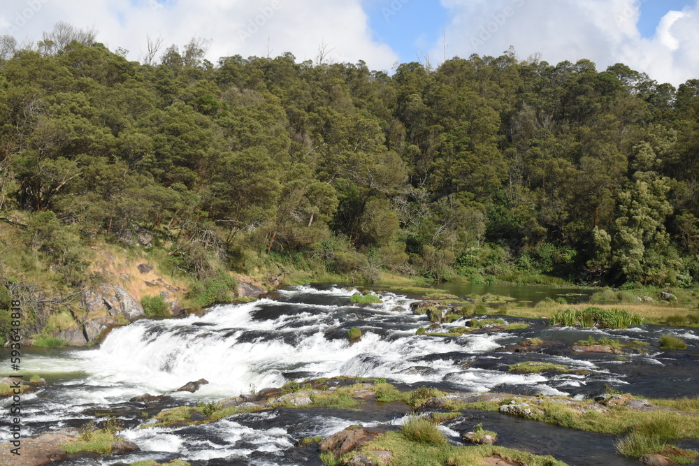 River flowing with green hills and blue sky River flowing with green hills and blue sky