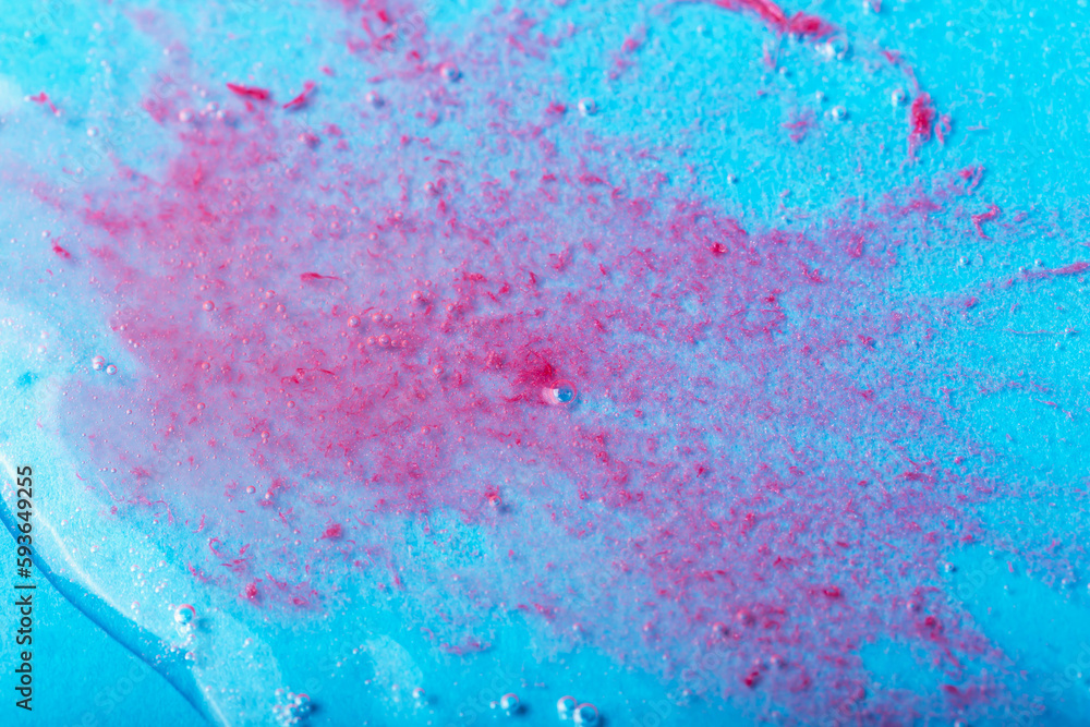Obraz premium Red particles in transparent liquid with bubbles on blue background. Laboratory studies. Cosmetics, gel, transparent texture, lotion. Selective focus, defocus