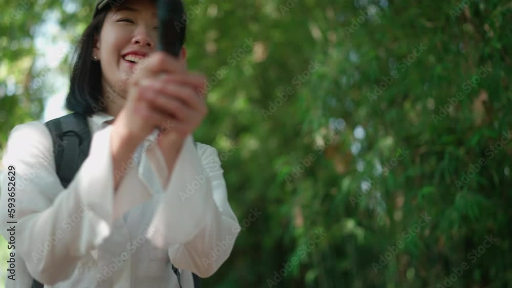 Young Asian woman traveler hiking or trekking in nature outdoor trip, using smartphone camera to selfie with smile and happy fun with natural forest landscape scene, tourist lifestyle go to mountain Young Asian woman traveler hiking or trekking in nature outdoor trip, using smartphone camera to selfie with smile and happy fun with natural forest landscape scene, tourist lifestyle go to mountain