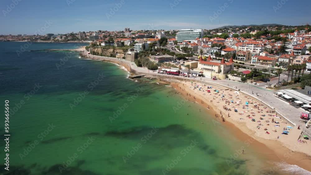 Aerial view approaching Praia da Poca Beach, full of tourists enjoying a warm sunny day, in Estoril, Lisbon, Portugal Aerial view approaching Praia da Poca Beach, full of tourists enjoying a warm sunny day, in Estoril, Lisbon, Portugal