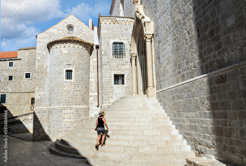 Woman in hat walking up the stairs of the church of Saint Dominic, Dominican monastery in the old town of Dubrovnik, Croatia. © Toni