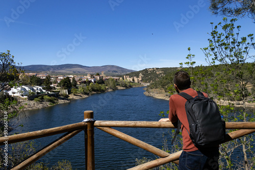 Man looking towards the town of Buitrago del Lozoya at the Pinarcillo viewpoint overlooking the Lozoya River.