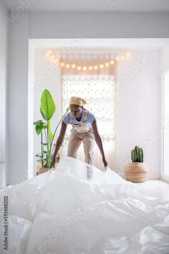 African American painter protecting floor with film