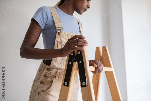 African American female painter adjusting ladder