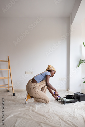 Black woman preparing to paint wall in daytime