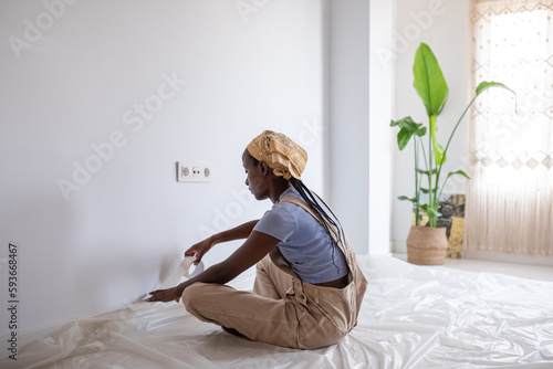 African American woman preparing to color wall at home