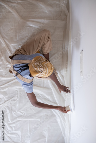 Black painter sticking tape on wall during renovation