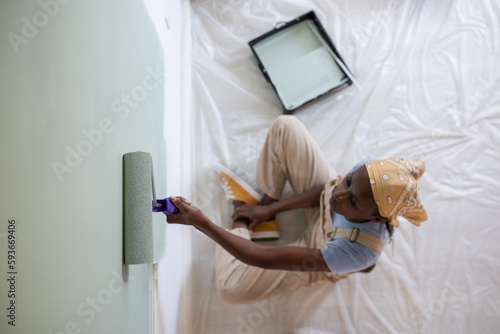 Black painter sitting on floor during renovation
