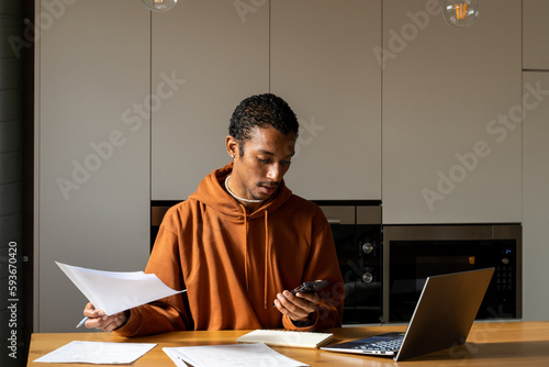 Man paying utility bills from home calculating expenses