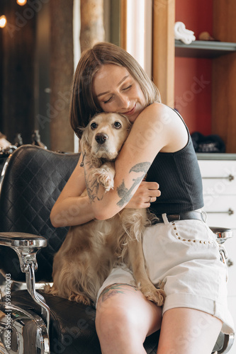 Woman hugging dog in barbershop photo