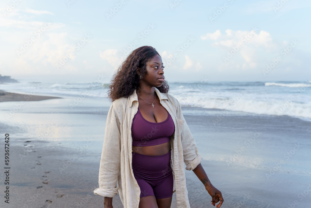 © Jovo Jovanovic/Stocksy - Woman walking at the beach