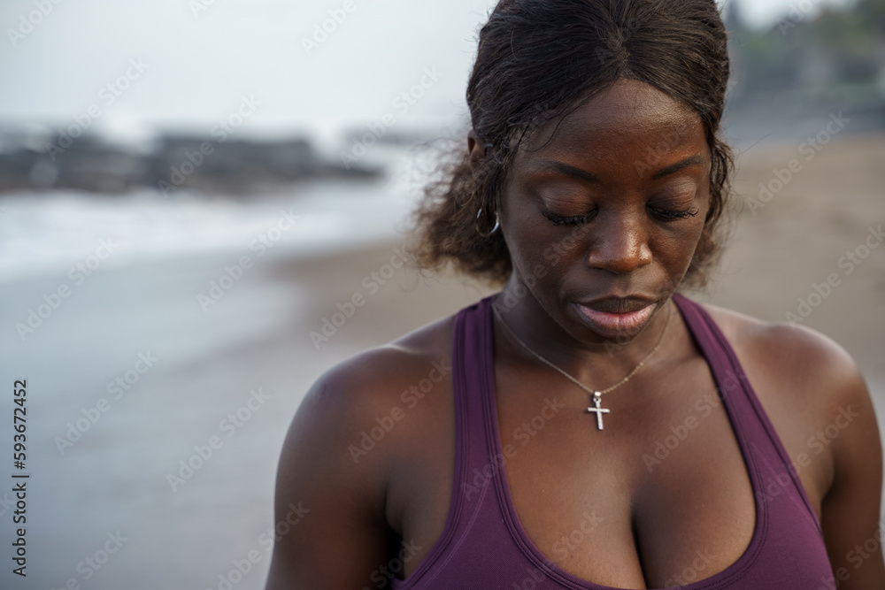© Jovo Jovanovic/Stocksy - Woman at the beach looking down upper body closeup