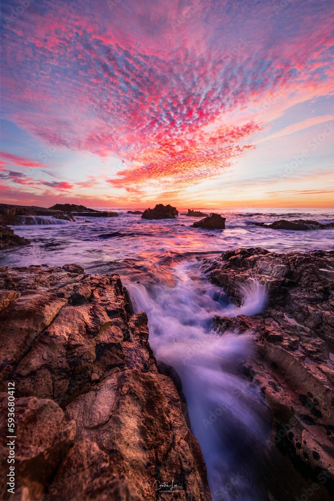 Vertical long exposure shot of a rocky beach at sunset in Cascais, Portugal.