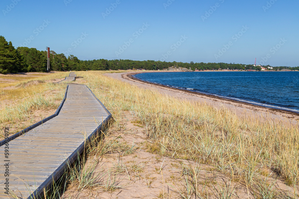 Wooden boardwalk at the Tulliniemi beach in Hanko, Finland, on a sunny day in the summer.