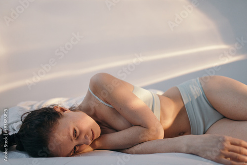 Depressed woman lying on bed photo