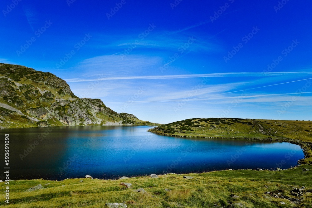 Seven Rila lakes view with green fields and mountains around, clear sky background
