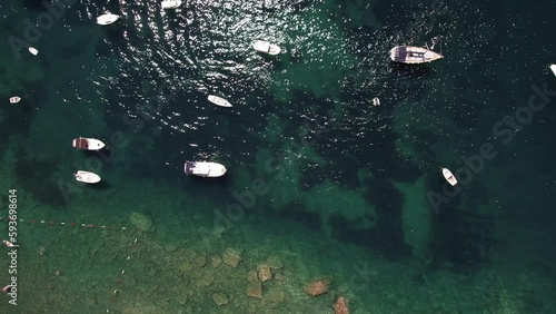 Aerial video of boats, yacht, docked in harbor tropical clear green water sea.
