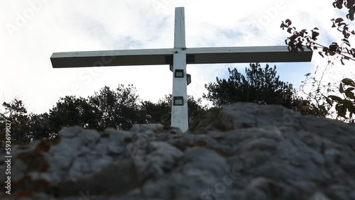 Undershot of wooden cross on the mountains, trees against cloudy sky photo