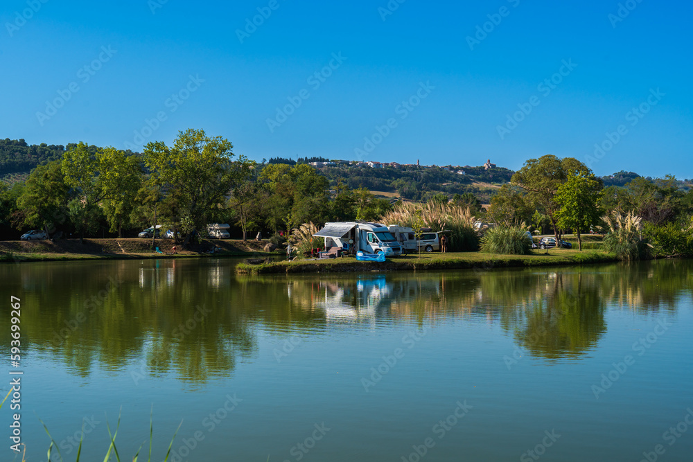Motorhomes on the lake by the river with camping tables, sport fishing for relaxation, summer travel and outdoor recreation, authentic sustainability and natural beauty of nature Motorhomes on the lake by the river with camping tables, sport fishing for relaxation, summer travel and outdoor recreation, authentic sustainability and natural beauty of nature