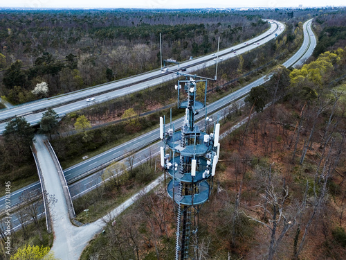 aerial view of a cellphone tower with the highway and the forest in the background