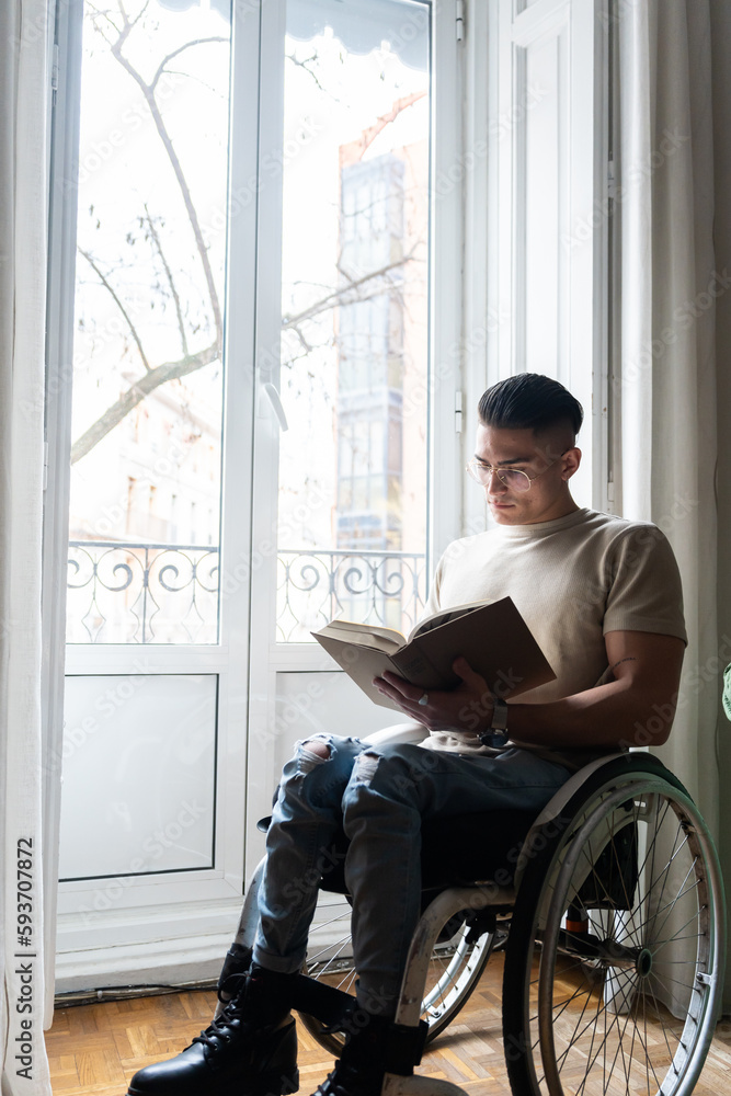 Young Man With A Disability Reading A Book Young Man With A Disability Reading A Book