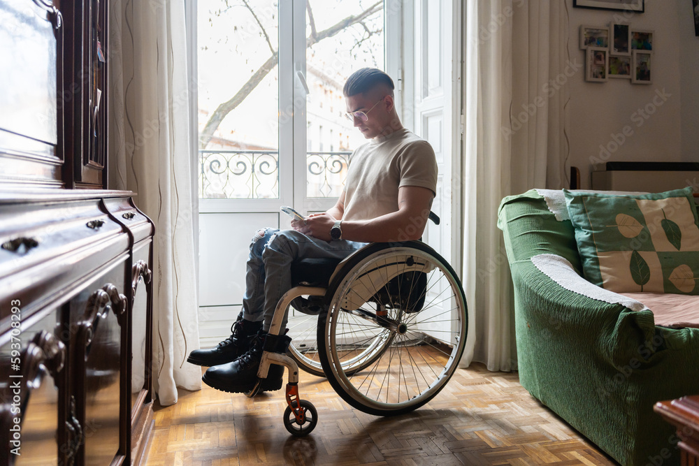 Man With Paraplegia Uses A Smartphone At Home. Man With Paraplegia Uses A Smartphone At Home.