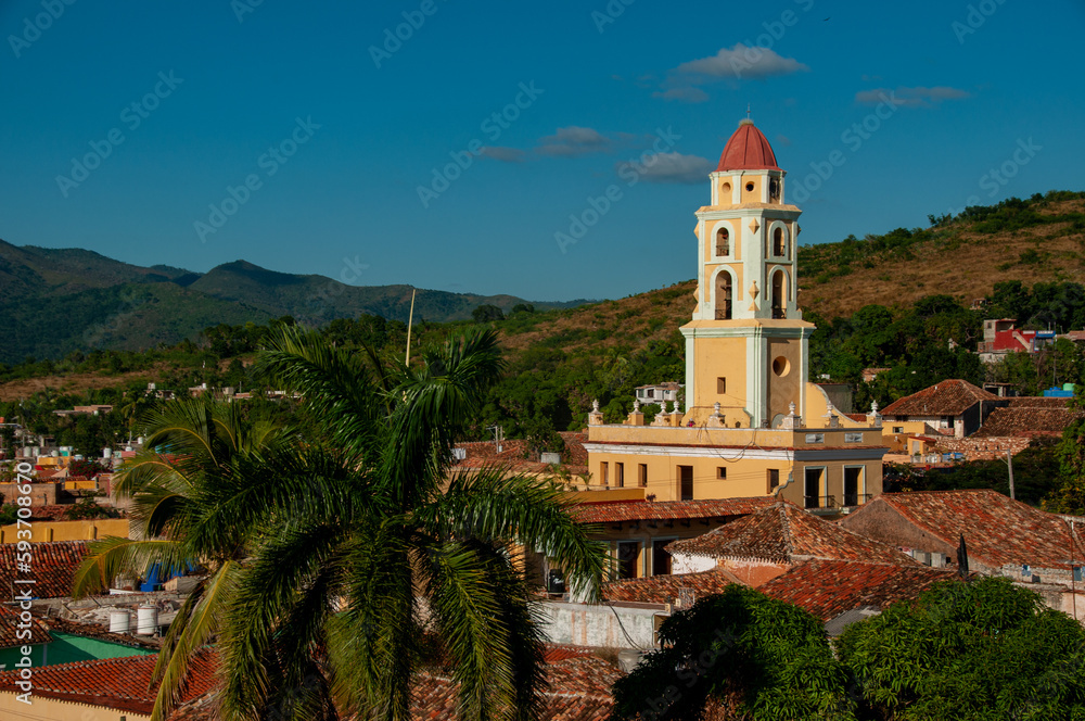 A tower surrounded by buildings and mountains in the city of Trinidad