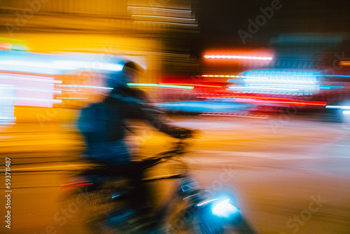 Conceptual photo of a delivery man on a bike in a night city at speed photo