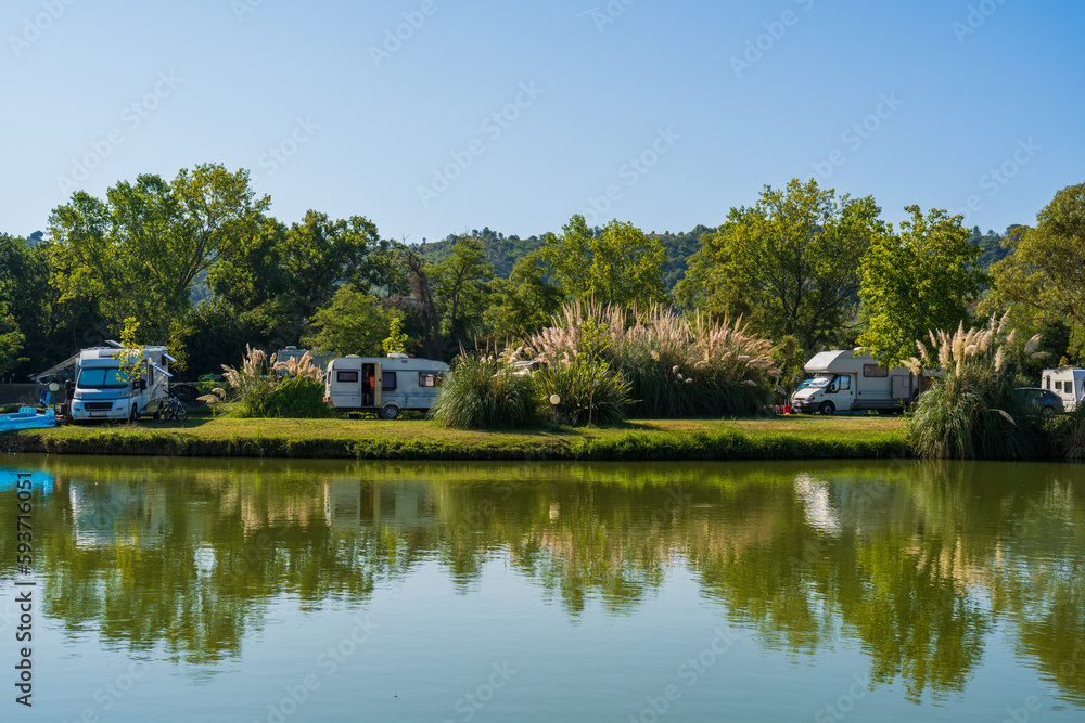 Motorhomes and bicycles on the lake by the river with camping tables, sport fishing and cycling for relaxation, summer travel and outdoor recreation, authentic sustainability, natural beauty of nature Motorhomes and bicycles on the lake by the river with camping tables, sport fishing and cycling for relaxation, summer travel and outdoor recreation, authentic sustainability, natural beauty of nature