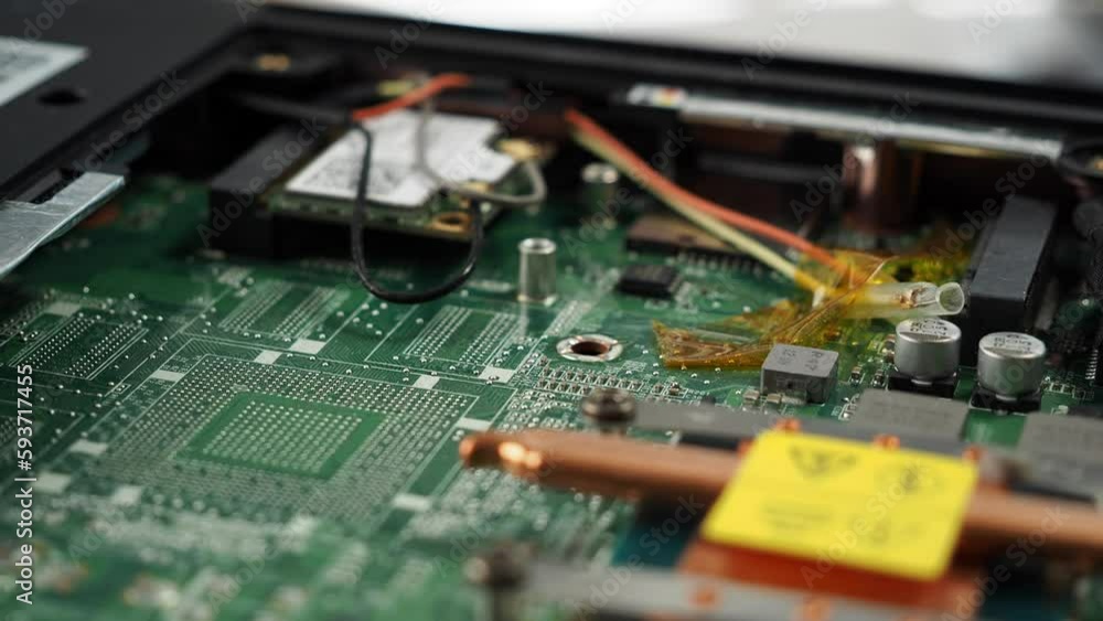 Electronic board of an old broken laptop. Rotating Dusty broken laptop in repair. Electronic board of an old broken laptop. Rotating Dusty broken laptop in repair.
