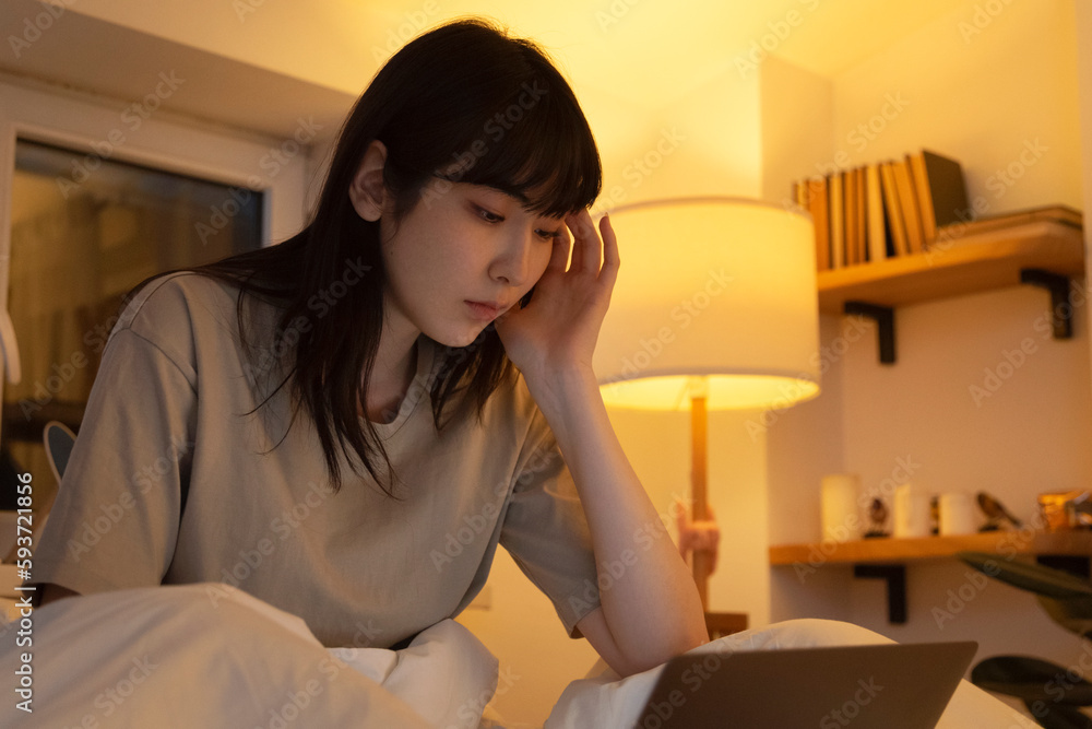 Young Asian woman watching film on computer Young Asian woman watching film on computer