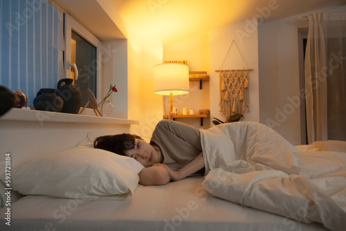 Asian woman lying in bed having insomnia photo
