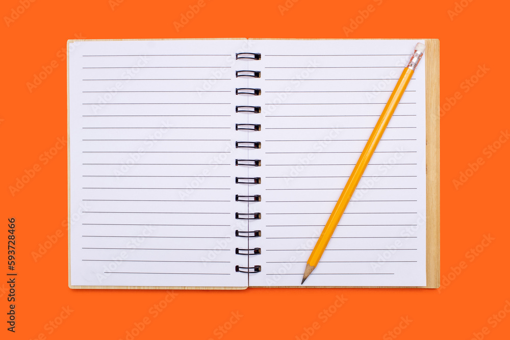 An open notebook with a binder and a yellow pencil on an orange background. Open notepad with blank sheets in top view. Free space for text. Blank notebook pages ready to be used in design An open notebook with a binder and a yellow pencil on an orange background. Open notepad with blank sheets in top view. Free space for text. Blank notebook pages ready to be used in design