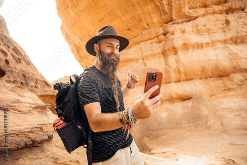 Traveler with beard using mobile phone photo