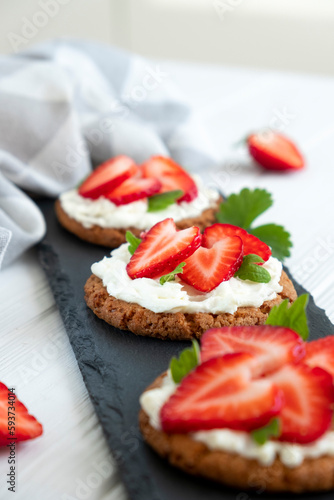 Healthy sandwich with strawberry and cream cheese on slate board. Tasty breakfast. Clean eating, diet or easy recipe of vegetarian sandwich for vegan menu.