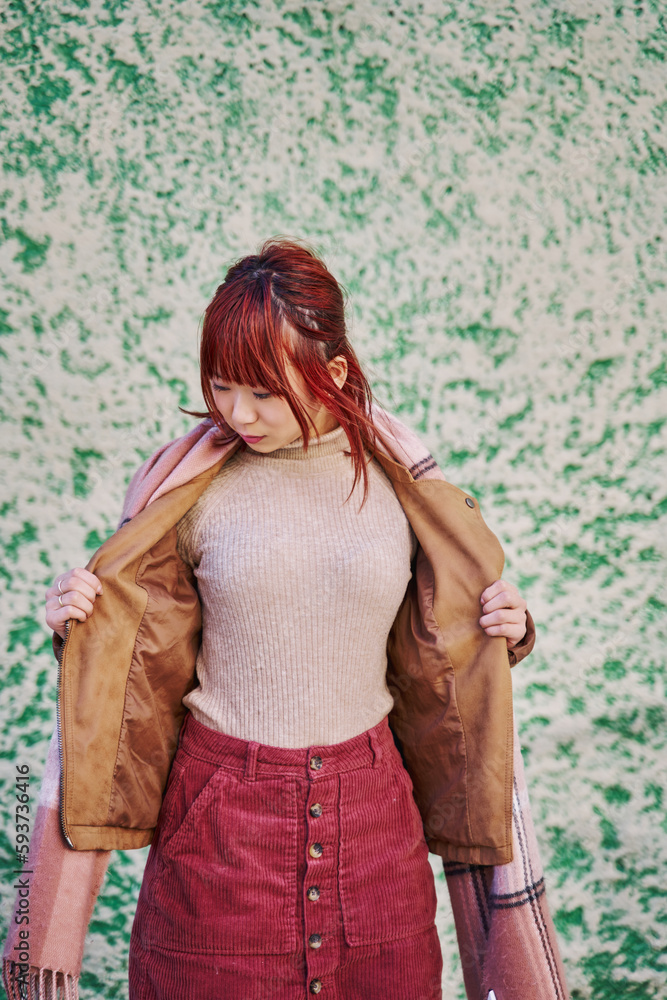 Fototapeta premium vertical portrait of a young asian woman opening her jacket