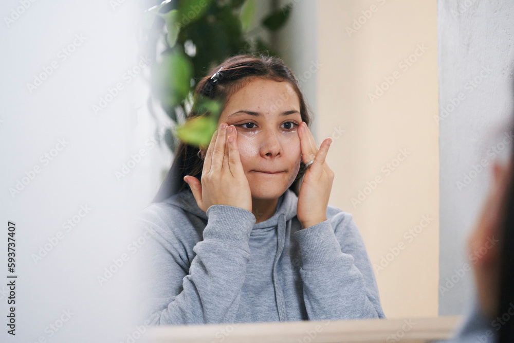 Young lady applying cleansing gel on face in bathroom Young lady applying cleansing gel on face in bathroom
