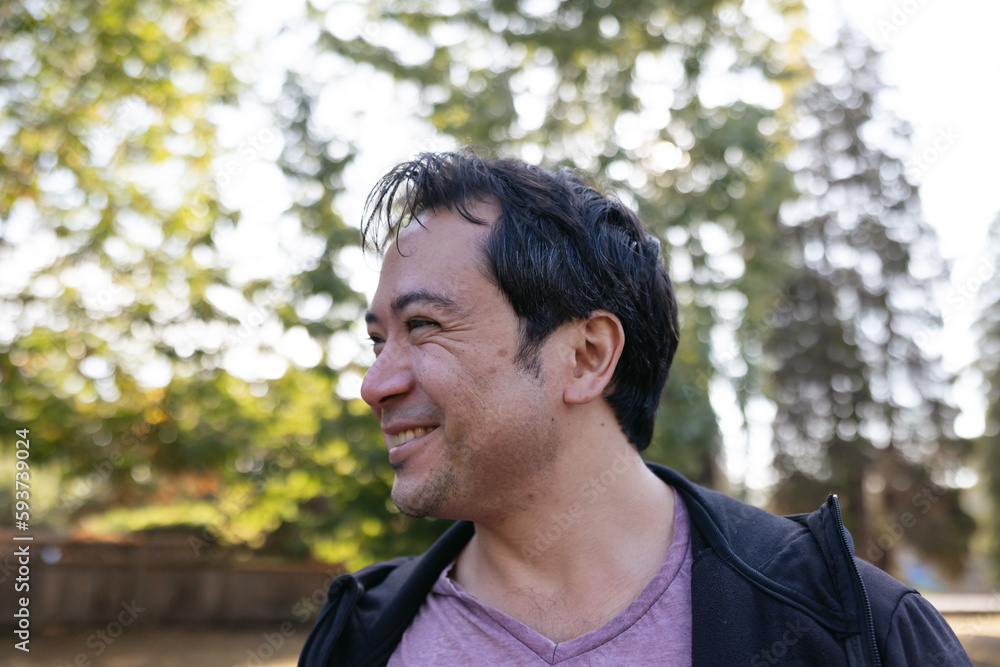 Smiling man outside in nature park. Smiling man outside in nature park.
