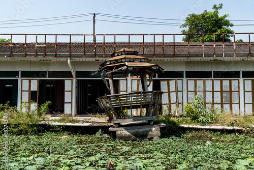 A broken old wooden gazebo in front of water lilies in Thailand photo