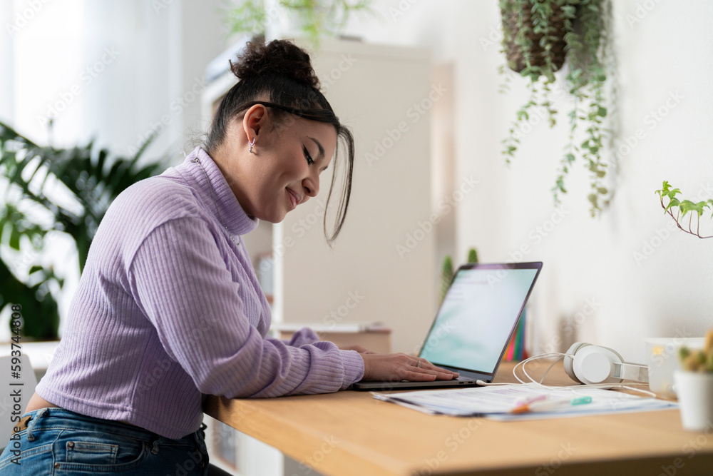 Focused female student using laptop at home Focused female student using laptop at home