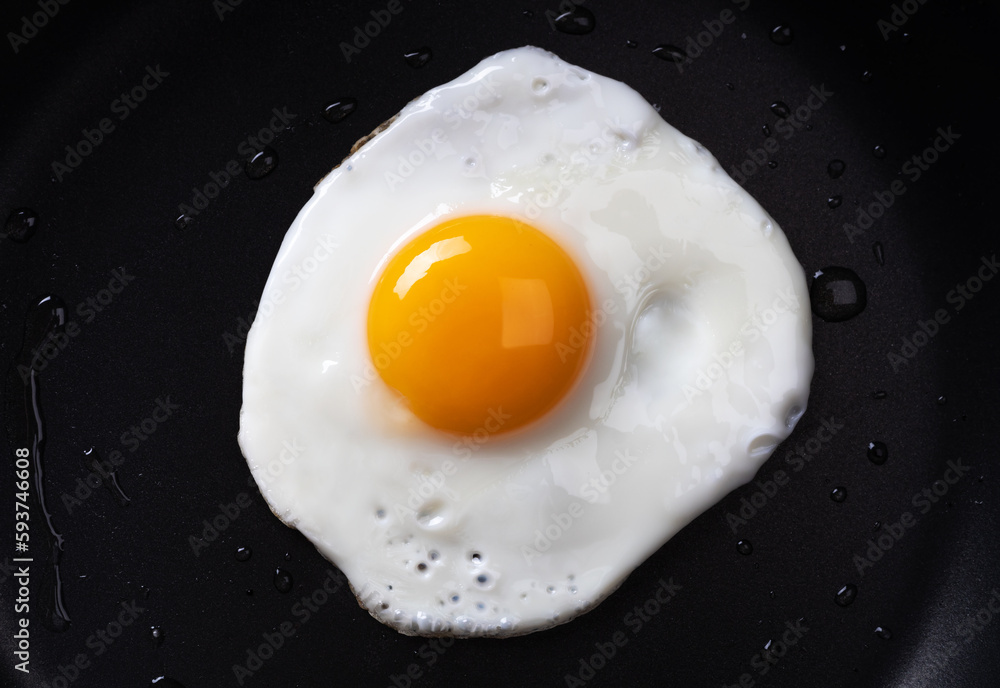 Fried egg in a frying pan. Simple breakfast. Close up. Fried egg in a frying pan. Simple breakfast. Close up.