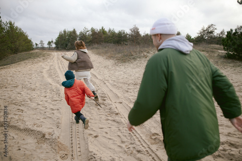 father and mother play outdoor games with son photo