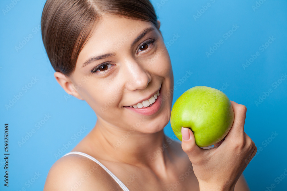 Healthy white teeth, portrait of sporty smiling woman with green apple Healthy white teeth, portrait of sporty smiling woman with green apple
