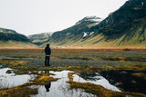 Young man looking across view of snow topped mountains in Iceland