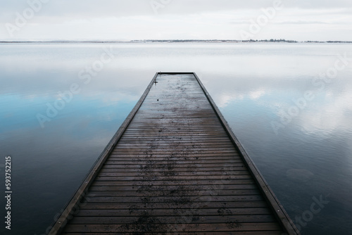 Wooden jetty leads into the icy lake 