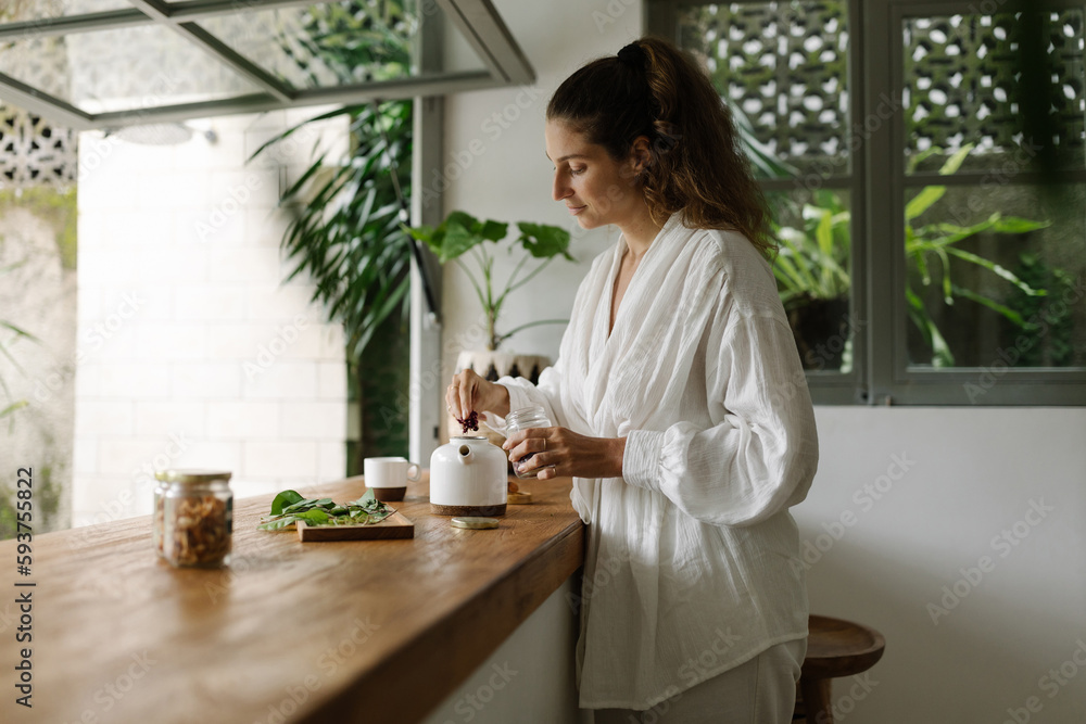 Portrait of cheerful young woman preparing tea Portrait of cheerful young woman preparing tea