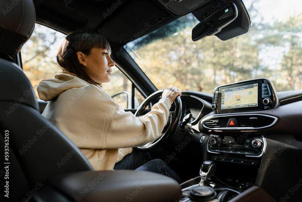Woman using navigator while driving a car Woman using navigator while driving a car