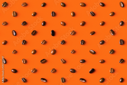Overhead view of coffee beans on orange background